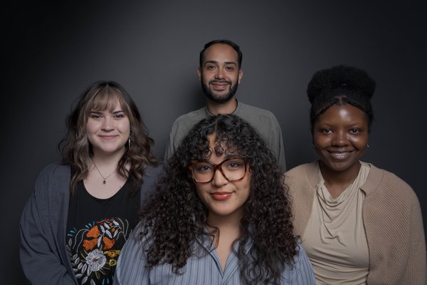 Photo by Carlos Cruz Portrait of four interns with a dark grey background